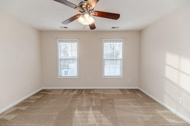 carpeted empty room featuring visible vents, baseboards, and ceiling fan