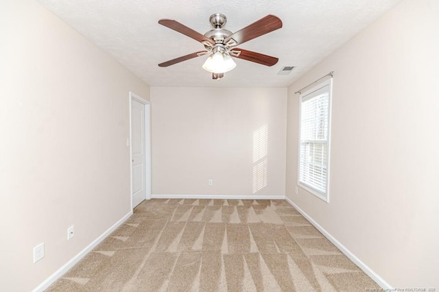 unfurnished room featuring visible vents, light carpet, a ceiling fan, a textured ceiling, and baseboards