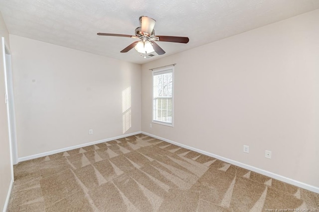 carpeted empty room with a textured ceiling, baseboards, and ceiling fan