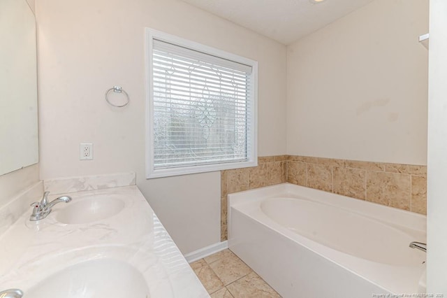 bathroom featuring tile patterned flooring, double vanity, a garden tub, and a sink