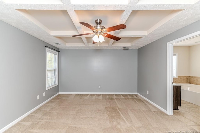 unfurnished room with beam ceiling, a ceiling fan, coffered ceiling, baseboards, and light colored carpet