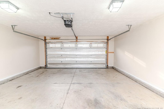 garage featuring a garage door opener and baseboards