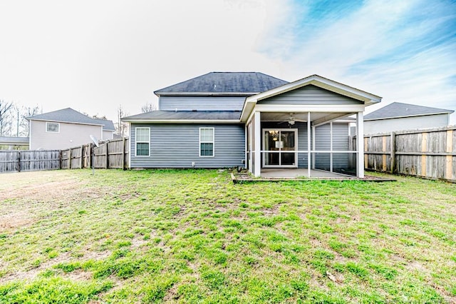 back of house with a lawn, a fenced backyard, and a sunroom