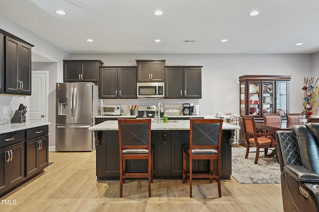 kitchen with open floor plan, recessed lighting, light wood-type flooring, and appliances with stainless steel finishes