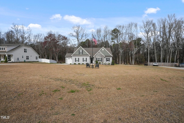 view of front facade featuring a garage, a front lawn, and fence