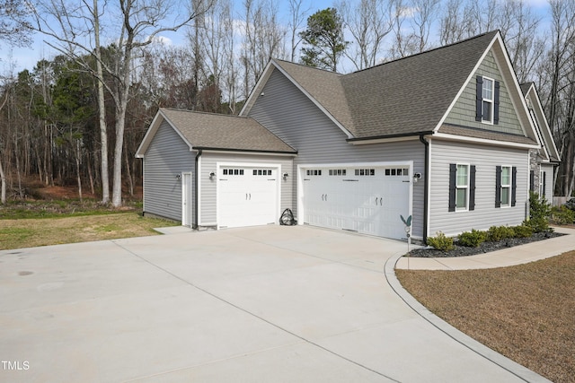 view of home's exterior with roof with shingles, concrete driveway, and an attached garage