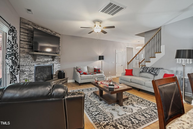 living room with visible vents, wood finished floors, ceiling fan, and stairs