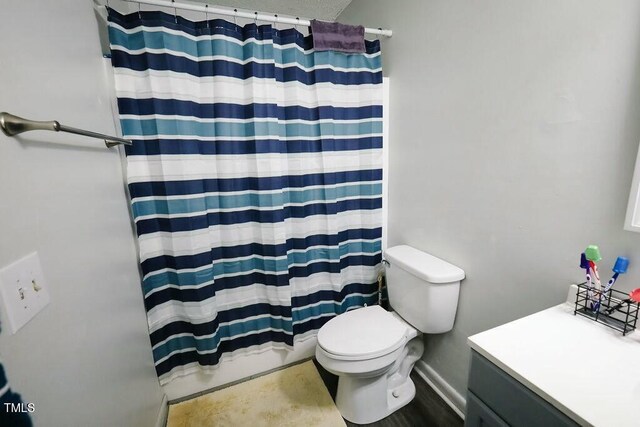 full bath with vanity, a shower with shower curtain, and toilet