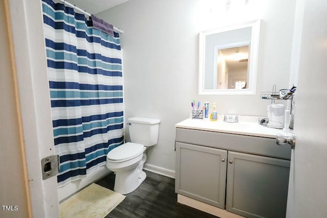 bathroom featuring toilet, curtained shower, wood finished floors, baseboards, and vanity