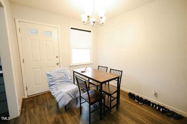 dining area featuring a notable chandelier, wood finished floors, and baseboards