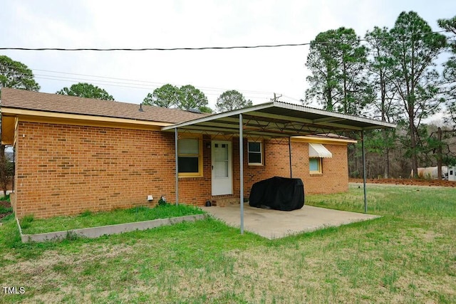 rear view of property featuring a patio area, brick siding, and a lawn