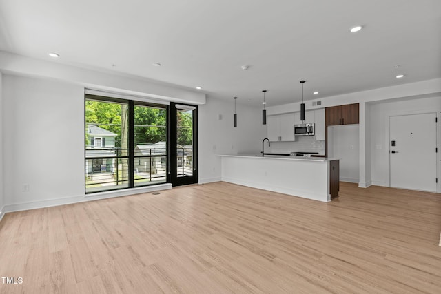 unfurnished living room with visible vents, recessed lighting, baseboards, and light wood finished floors