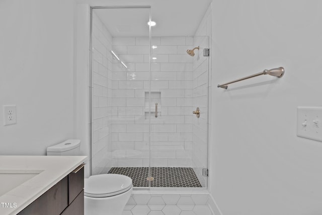 bathroom with a shower stall, toilet, and vanity