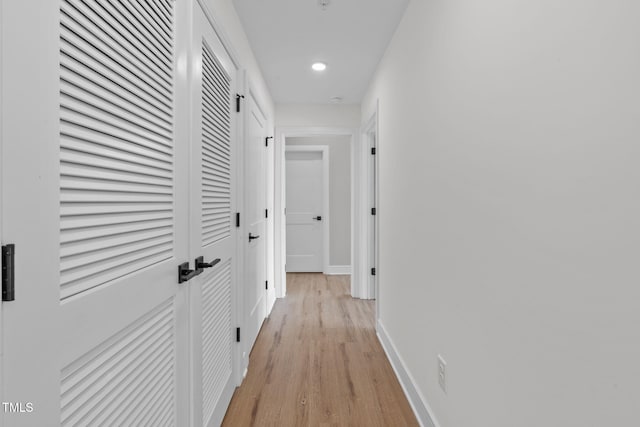 hallway featuring recessed lighting, baseboards, and light wood finished floors