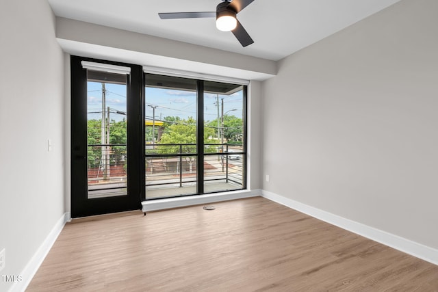 unfurnished room with a ceiling fan, baseboards, and light wood finished floors