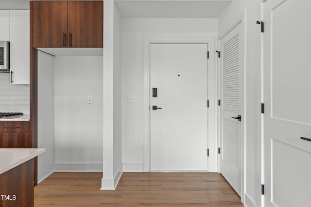 interior space with baseboards and light wood finished floors