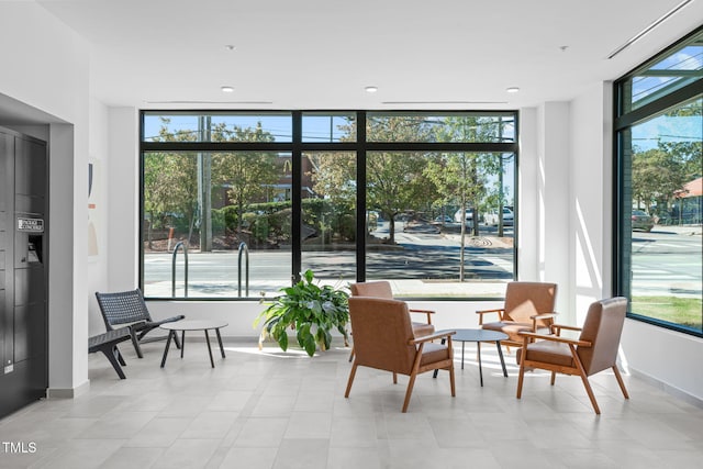 sitting room featuring baseboards and a healthy amount of sunlight