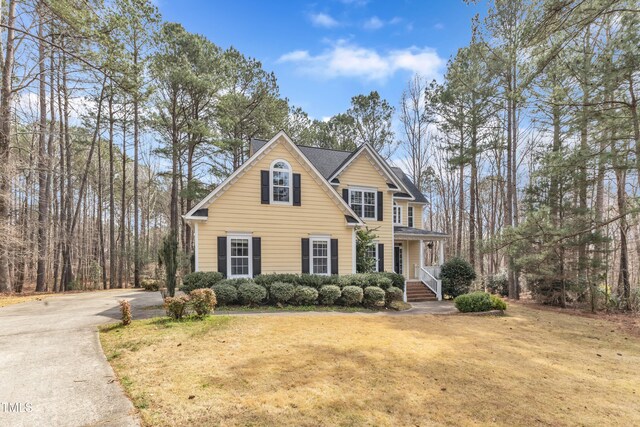 view of front of house featuring concrete driveway and a front lawn
