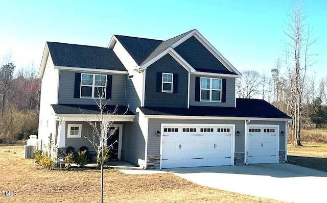 craftsman inspired home with an attached garage, stone siding, and driveway