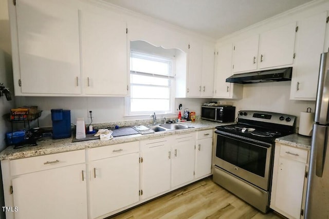 kitchen featuring under cabinet range hood, a sink, stainless steel appliances, white cabinets, and light countertops