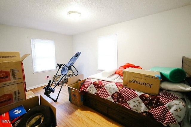 bedroom with wood finished floors and a textured ceiling