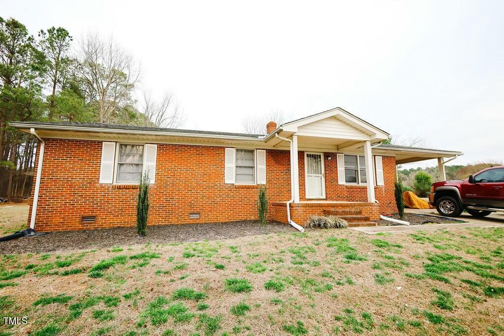 ranch-style house with brick siding, crawl space, and a front yard