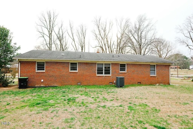 rear view of house with crawl space, central air condition unit, a yard, and brick siding