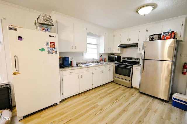 kitchen featuring light wood finished floors, light countertops, white cabinets, appliances with stainless steel finishes, and under cabinet range hood