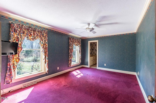 unfurnished room featuring a ceiling fan, visible vents, carpet floors, ornamental molding, and a textured ceiling