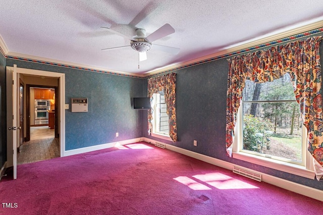 unfurnished room with crown molding, carpet, visible vents, and a textured ceiling