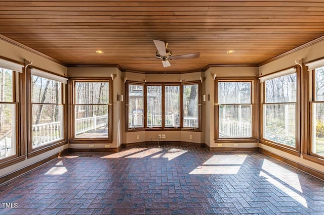 unfurnished sunroom with a healthy amount of sunlight, wood ceiling, and ceiling fan