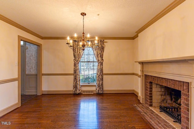 unfurnished living room with visible vents, a textured ceiling, wood finished floors, a brick fireplace, and a chandelier