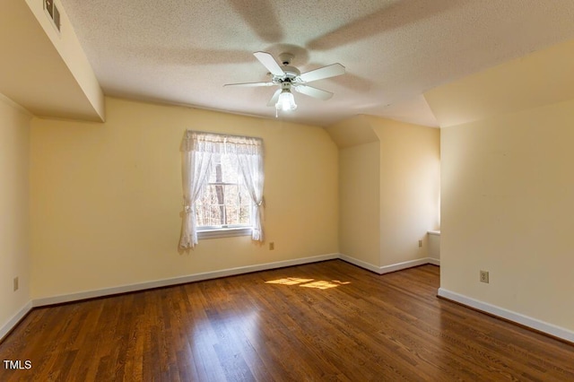 bonus room featuring lofted ceiling, a ceiling fan, a textured ceiling, wood finished floors, and baseboards