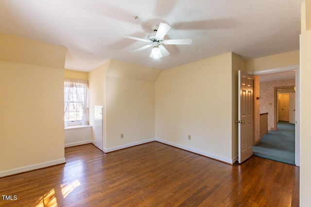 spare room featuring baseboards, wood finished floors, and a ceiling fan