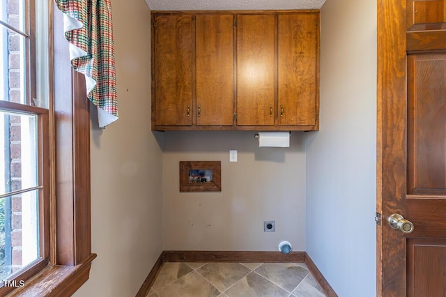 clothes washing area featuring electric dryer hookup, baseboards, cabinet space, and washer hookup