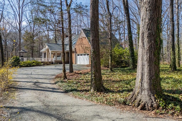 view of front of property with a porch, driveway, and a garage