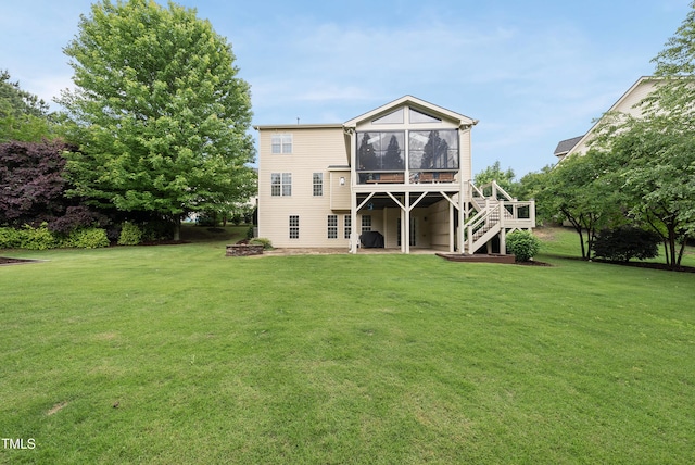 back of house with a sunroom, stairway, a yard, and a patio