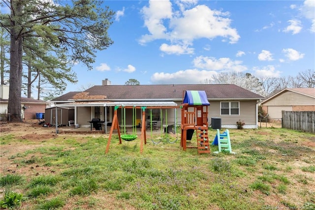 rear view of house with a playground, fence, cooling unit, a chimney, and a storage shed