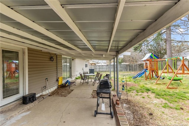 view of patio / terrace featuring area for grilling, a playground, and a fenced backyard