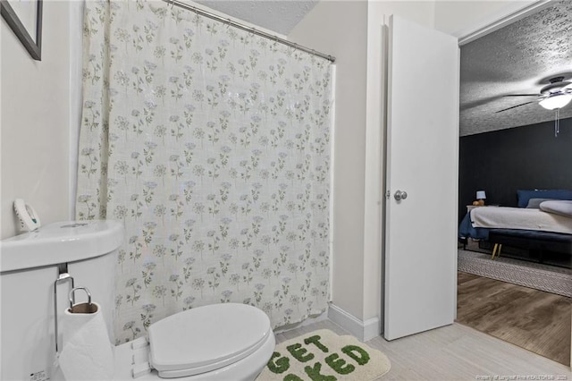 ensuite bathroom featuring toilet, a ceiling fan, a textured ceiling, wood finished floors, and ensuite bath