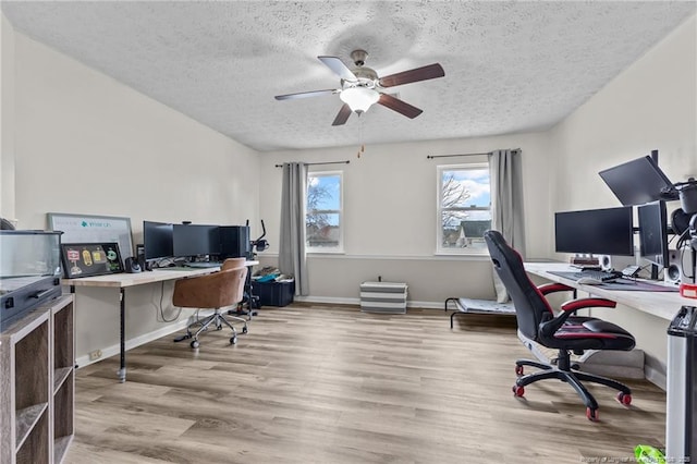 office with a textured ceiling, wood finished floors, baseboards, and ceiling fan