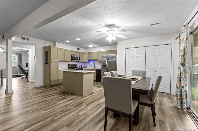 dining room featuring wood finished floors, visible vents, and a textured ceiling