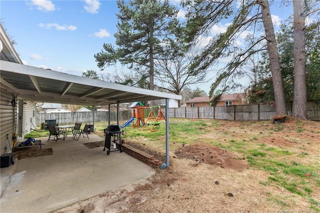 view of yard featuring a playground, a fenced backyard, and a patio area