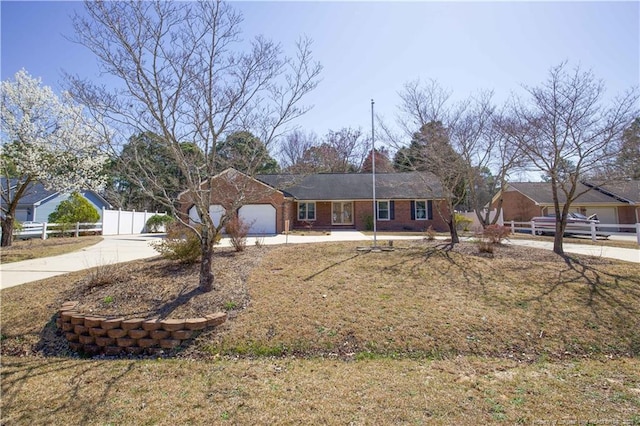 ranch-style home featuring a garage, concrete driveway, and fence