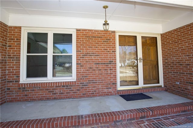 entrance to property featuring brick siding