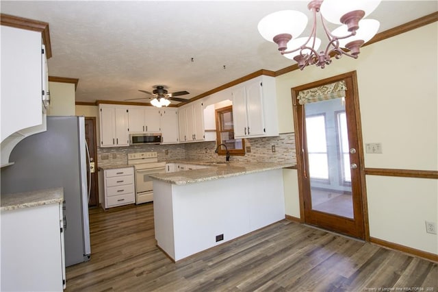 kitchen featuring stainless steel appliances, a peninsula, white cabinets, and dark wood-style floors