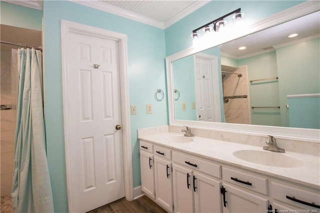 full bathroom with a sink, ornamental molding, double vanity, and a tile shower