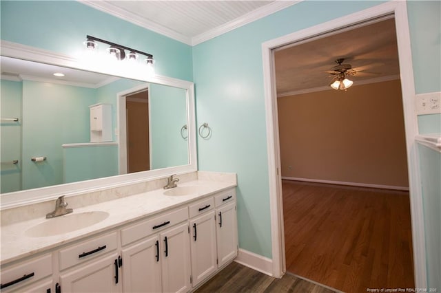 bathroom featuring double vanity, ornamental molding, wood finished floors, and a sink