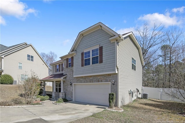 view of front of home with fence, central air condition unit, a garage, stone siding, and driveway