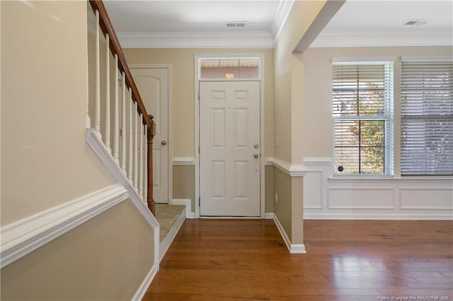 entrance foyer featuring crown molding, stairway, wood finished floors, and visible vents